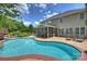 Large backyard with pool, landscaped gardens, screened-in porch, and exterior of a home with beige siding at 2300 Lord Anson Dr, Waxhaw, NC 28173