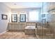 Bright bathroom featuring double sinks, a soaking tub, and a glass shower at 2300 Lord Anson Dr, Waxhaw, NC 28173