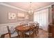 Elegant dining room with decorative chandelier, wainscoting, and natural light at 2300 Lord Anson Dr, Waxhaw, NC 28173