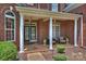 Charming front porch with brick columns, seating area, and a welcoming entrance at 2300 Lord Anson Dr, Waxhaw, NC 28173