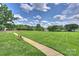 Expansive green space with a sidewalk and bench for relaxing and enjoying the scenery at 2300 Lord Anson Dr, Waxhaw, NC 28173