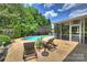 Inviting backyard with an in-ground pool, lush greenery, lounge chairs, and a screened-in porch at 2300 Lord Anson Dr, Waxhaw, NC 28173