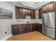 Home bar area complete with dark wood cabinets, stainless steel fridge, and granite countertop at 270 Sandhills Ct, Mooresville, NC 28115