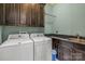 Functional laundry room with cabinetry, sink, and modern washer and dryer units at 270 Sandhills Ct, Mooresville, NC 28115