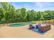 Inviting in-ground pool surrounded by lush greenery and comfortable outdoor seating area with a wrought iron fence at 270 Sandhills Ct, Mooresville, NC 28115