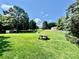 Expansive backyard with lush green grass, mature trees, and a picnic table for outdoor enjoyment at 2810 Elizabeth Ave, Shelby, NC 28150