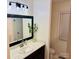 Updated bathroom with a modern vanity, marble countertop, decorative mirror, and a window at 312 Shady Ln, Lincolnton, NC 28092