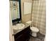 Cozy bathroom with a vanity, dark wood cabinets, framed mirror, tile floors, and shower/tub at 312 Shady Ln, Lincolnton, NC 28092