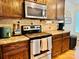 Modern kitchen with stainless steel appliances, wooden cabinets, granite countertops and tile backsplash at 312 Shady Ln, Lincolnton, NC 28092