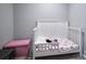 Well-lit bedroom featuring a white crib, pink storage, and neutral gray walls and carpet at 327 Wilkes Place Dr, Fort Mill, SC 29715