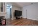 Open bonus room featuring hardwood floors, a large TV, and stairs, perfect for entertainment and relaxation at 327 Wilkes Place Dr, Fort Mill, SC 29715