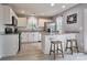 Modern kitchen featuring white cabinets, stainless steel appliances, and a breakfast bar with stools at 327 Wilkes Place Dr, Fort Mill, SC 29715