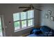 Bright living room with a ceiling fan, large windows, and a comfortable blue sofa, perfect for relaxation and natural light at 327 Wilkes Place Dr, Fort Mill, SC 29715