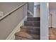 Carpeted staircase with white railings leads to the upper level, providing a seamless transition between floors at 327 Wilkes Place Dr, Fort Mill, SC 29715