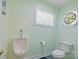 This bathroom features a toilet and urinal against a light green wall at 408 Emerald Bay Dr, Salisbury, NC 28146