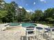 Inviting backyard pool and spa with ample seating surrounded by mature trees offering a private oasis at 408 Emerald Bay Dr, Salisbury, NC 28146