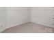 Bedroom featuring neutral carpet, white trim, base molding, and single door at 4368 Yoruk Forest Ln, Charlotte, NC 28211