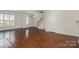 Bright living room with wood floors, access to the staircase, and plenty of natural light at 4368 Yoruk Forest Ln, Charlotte, NC 28211