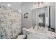 Well-lit bathroom featuring a shower with a floral curtain, a vanity with a white countertop, and modern fixtures at 4532 Stellata Loop, Sherrills Ford, NC 28673
