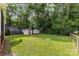 Large backyard with two storage sheds, mature trees, and a grassy lawn at 4915 Galax Dr, Charlotte, NC 28213