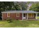 Charming brick ranch home with red shutters, green lawn, and mature trees at 4915 Galax Dr, Charlotte, NC 28213