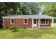 Charming brick ranch home with red shutters, green lawn, and mature trees at 4915 Galax Dr, Charlotte, NC 28213