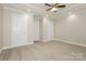 Spacious bedroom with neutral carpeting, complemented by three white panel doors and a ceiling fan at 507 E Cloninger St, Dallas, NC 28034