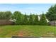 Private backyard features a level lawn, mature trees, and a wood fence at 507 Galesburg Dr, Monroe, NC 28110