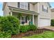 Close-up view of the front of this two-story home featuring manicured landscaping and a teal front door at 507 Galesburg Dr, Monroe, NC 28110