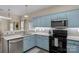 This kitchen features blue cabinets, stainless steel appliances, light countertops and backsplash, and modern lighting at 507 Galesburg Dr, Monroe, NC 28110