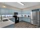 This kitchen features blue cabinets, stainless steel appliances, light countertops, and modern backsplash at 507 Galesburg Dr, Monroe, NC 28110