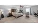 Spacious bedroom features a large bed, a treadmill and sitting area, ceiling fan, and ample light at 507 Galesburg Dr, Monroe, NC 28110