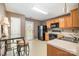 Classic kitchen featuring wooden cabinets, black appliances, and a cozy breakfast nook with bar seating at 5402 Harris Cove Dr, Charlotte, NC 28269