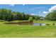 Scenic backyard featuring a serene pond and lush landscaping, creating a peaceful and private outdoor space at 6504 Sybil Ct, Indian Trail, NC 28079