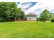 Large backyard with lush green lawn and a backdrop of mature trees at 6504 Sybil Ct, Indian Trail, NC 28079