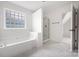 Modern bathroom featuring soaking tub, glass shower, and sleek tile flooring at 6504 Sybil Ct, Indian Trail, NC 28079