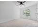 Bright bedroom with a ceiling fan, neutral carpeting, and natural light from the window at 6504 Sybil Ct, Indian Trail, NC 28079