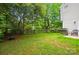 Spacious backyard with a grill, fire pit, seating, and mature trees, perfect for outdoor entertaining at 8014 Sherington Way, Charlotte, NC 28227