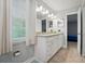 Bright bathroom featuring a double sink vanity, granite counters, and a window with natural light at 8014 Sherington Way, Charlotte, NC 28227