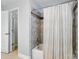 Updated bathroom showcasing a tiled shower with wood accents and neutral shower curtain at 8014 Sherington Way, Charlotte, NC 28227