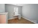 Cozy bedroom featuring neutral walls and carpet, a window, and a desk with drawers at 8014 Sherington Way, Charlotte, NC 28227