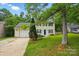 Inviting home with lush green lawn and mature trees providing shade and curb appeal at 8014 Sherington Way, Charlotte, NC 28227