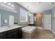 Luxurious primary bathroom with double sink vanity, soaking tub, and glass-enclosed shower, creating a spa-like experience at 837 Tyne Dr, Fort Mill, SC 29715