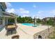 An in-ground pool is surrounded by concrete, an outdoor table under a porch and a pergola with mature trees in the background at 837 Tyne Dr, Fort Mill, SC 29715