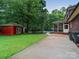 Spacious backyard with a large pool, a storage shed, and a brick home at 8527 Foxbridge Dr, Matthews, NC 28104