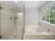 Modern bathroom with soaking tub and a glass door shower at 8527 Foxbridge Dr, Matthews, NC 28104