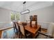 Formal dining room featuring a wooden table, six upholstered chairs, a modern chandelier, and natural light at 8527 Foxbridge Dr, Matthews, NC 28104