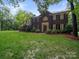 Stately two-story brick home featuring mature trees and a manicured lawn at 8527 Foxbridge Dr, Matthews, NC 28104