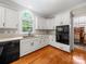 Bright kitchen featuring white cabinets, black appliances, quartz countertops, and a window over the sink at 8527 Foxbridge Dr, Matthews, NC 28104