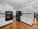 Well-equipped kitchen with white cabinets, black appliances, hardwood floors, and plenty of counter space at 8527 Foxbridge Dr, Matthews, NC 28104